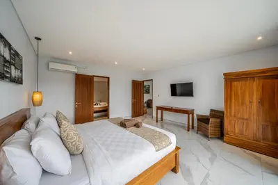 a bedroom with a white bed and a television at Luxury 2BR Villas in Seminyak Central in Seminyak