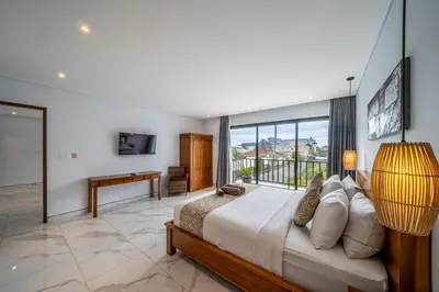 a bedroom with a bed and a large window at Luxury 2BR Villas in Seminyak Central in Seminyak