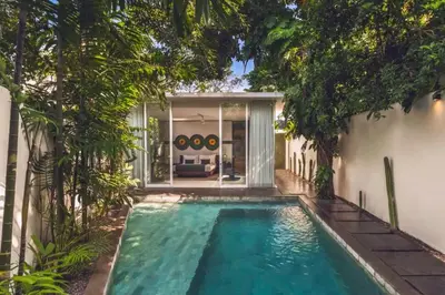 a swimming pool in the backyard of a house with trees at Chaesa Comfortable 1 BR Royal Private Pool Villa in Kerobokan