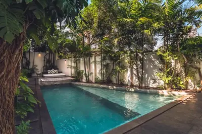 a swimming pool in a backyard with trees at Chaesa Comfortable 1 BR Royal Private Pool Villa in Kerobokan