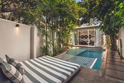 a swimming pool with a bed next to a house at Chaesa Comfortable 1 BR Royal Private Pool Villa in Kerobokan