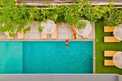 an overhead view of a man standing in a swimming pool at Varenya Cozy 1 BR Suite Twin Room in Kerobokan