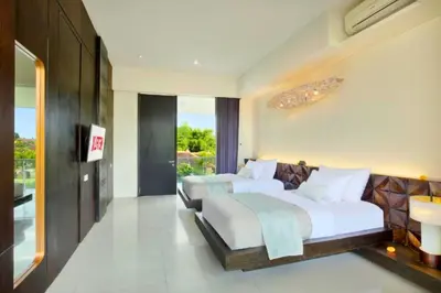 a bedroom with two beds and a large window at Varenya Cozy 1 BR Suite Twin Room in Kerobokan