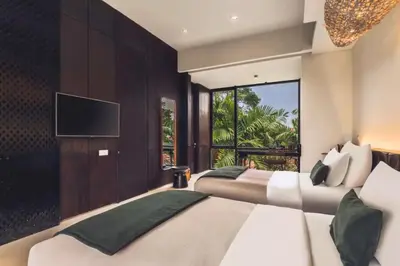 a bedroom with two beds and a flat screen tv at Varenya Cozy 1 BR Suite Twin Room in Kerobokan