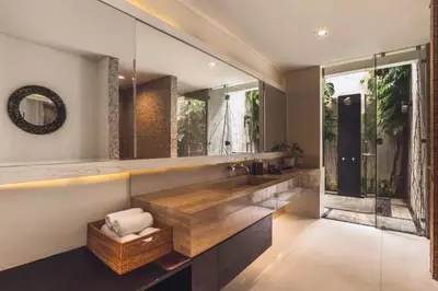 a bathroom with a sink and a large mirror at Varnika Peaceful 1 BR Suite Double Room in Kerobokan
