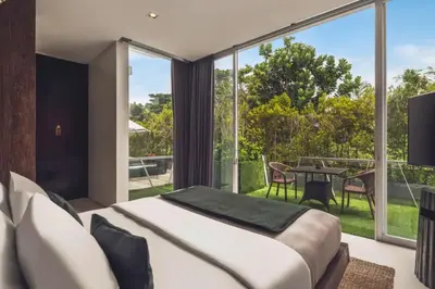 a bedroom with a large bed and a balcony at Varnika Peaceful 1 BR Suite Double Room in Kerobokan