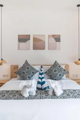 a bedroom with a bed with towels and pictures on the wall at 3BRVilla Minutes from Seminyak, Petitenget, Canggu in Kerobokan