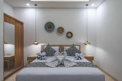 a bedroom with a bed with two swans on it at 3BRVilla Minutes from Seminyak, Petitenget, Canggu in Kerobokan