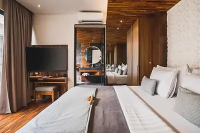 a bedroom with a bed and a desk and a television at Tarasari Stunning 1 BR Grand Private Pool Villa With Bathtub in Seminyak