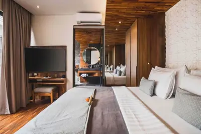 a bedroom with a bed with a desk and a television at Tarasari Stunning 1 BR Grand Private Pool Villa With Bathtub in Seminyak