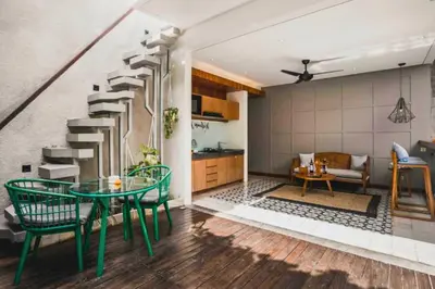 a living room with a staircase and a table and chairs at Tarasari Stunning 1 BR Grand Private Pool Villa With Bathtub in Seminyak