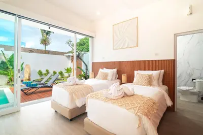 a bedroom with two beds and a balcony with a pool at Coastal Bliss Private 2BR Pool Villa Jimbaran in Jimbaran