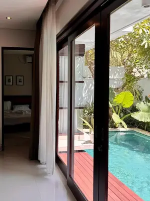 a room with a glass door leading to a swimming pool at Villa Hale Mahina, Bali in Kerobokan