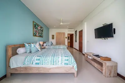 a bedroom with a bed and a flat screen tv at Villa Samsara 3BR Pool Villa Near Berawa Beach in Canggu