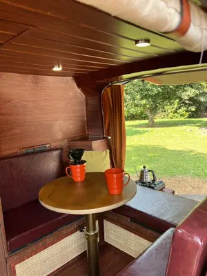 a table in the back of a train with two cups on it at Wandervan - Bali Campervan Rental in Kuta