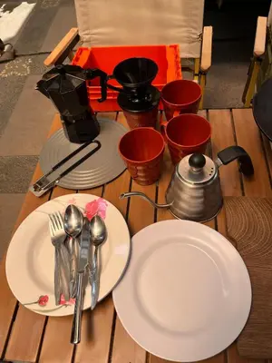 a wooden table with plates and utensils on it at Wandervan - Bali Campervan Rental in Kuta