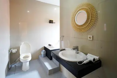 a bathroom with a sink and a toilet and a mirror at 6 Bedrooms Pool Twin Villa in West Sanur in Sanur