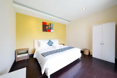 a bedroom with a large white bed and a cabinet at 6 Bedrooms Pool Twin Villa in West Sanur in Sanur