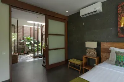 a bedroom with a bed and a chair and a window at Boutique Modern Luxury in the Heart of Seminyak in Seminyak