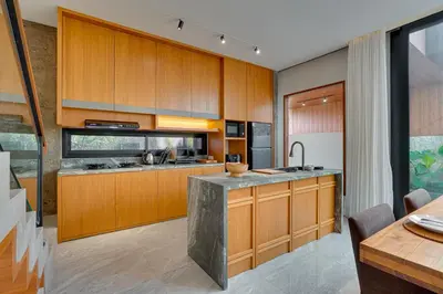 a kitchen with wooden cabinets and a counter top at Elegant Villa Vibhava 2BR in Central Umalas in Kerobokan