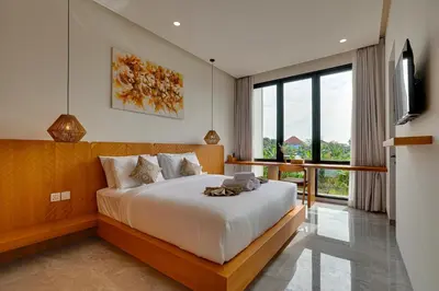 a bedroom with a large bed and a balcony at Elegant Villa Vibhava 2BR in Central Umalas in Kerobokan