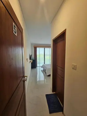 a hallway with a door leading to a bedroom at Kubu Semangka in Sanur