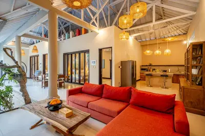 a living room with a red couch and a table at Villa Aditya Seminyak in Seminyak