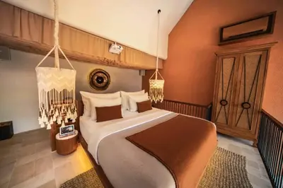 a bedroom with a large bed and a chandelier at Tamasvini Romantic 1 BR Grand Private Pool Villa With Bathtub in Seminyak