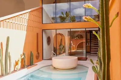 a bath tub in the middle of a house with a cactus at Tamasvini Romantic 1 BR Grand Private Pool Villa With Bathtub in Seminyak