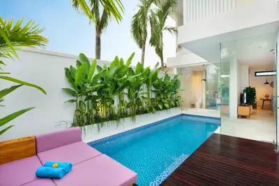 a living room with a pink couch and a swimming pool at Halina Cozy 2 BR Private Pool Villa With Bathtub in Legian