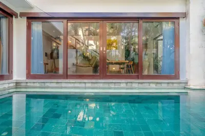 a swimming pool in front of a house at Stunning villa in Umalas center in Canggu
