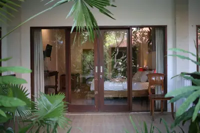 a glass door leading into a room with a bed at Kundalini Shakta Yoga Meditasi in Denpasar