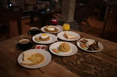 a wooden table with plates of food on it at Kundalini Shakta Yoga Meditasi in Denpasar