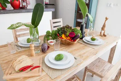 a table with plates of food and a basket of vegetables at Cozy 2br villa at the beach in Canggu