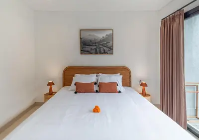 a bedroom with a large white bed with orange pillows at Villa Delila in Canguu in Canggu