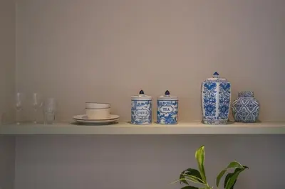 a shelf with blue and white vases on it at Anam Mani New Room Central Seminyak in Seminyak