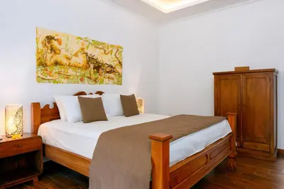 a bedroom with a bed and a painting on the wall at Beachside Luxury Private Villa in Sanur in Sanur