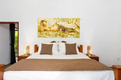 a bedroom with a bed with a painting on the wall at Beachside Luxury Private Villa in Sanur in Sanur