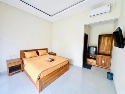 a bedroom with a bed and a tv in it at Umah Anami in Denpasar