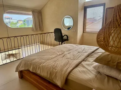 a bedroom with a bed with a chair and a mirror at LoftStyle Villa with nice Private Plunge Pool in Kerobokan