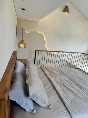 a bed with pillows on it in a room at LoftStyle Villa with nice Private Plunge Pool in Kerobokan