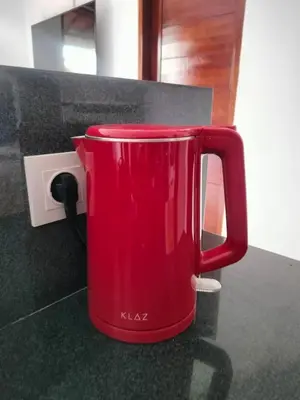 a red mug sitting on a counter next to a socket at Villa Toya in Legian