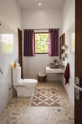 a bathroom with a toilet and a sink and a window at Nuansa Timur Residence in Jimbaran