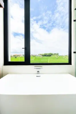 a window with a view of a green field at Casa Alden - 3BR Infinity Pool with Ricefield View in Kerobokan