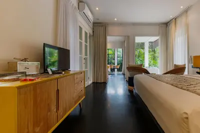 a hotel room with two beds and a television at Luxury with A Soul - Martini 2 1BR Villa Reimagined in Kerobokan