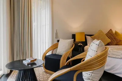a bedroom with a bed and a chair and a table at Luxury with A Soul - Martini 2 1BR Villa Reimagined in Kerobokan