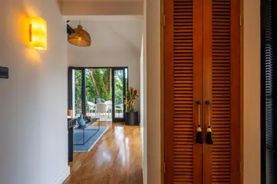 a hallway of a home with a wooden door at Walk into Serenity, Martini 3 - 1BR Treetop Villa in Kerobokan