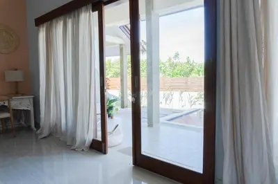 a mirror in a living room with a view of a pool at 2 Bedroom Villa with Private Pool & Kitchen in Jimbaran
