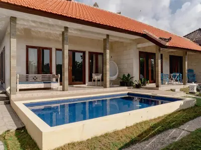 a swimming pool in front of a house at 2 Bedroom Villa with Private Pool & Kitchen in Jimbaran