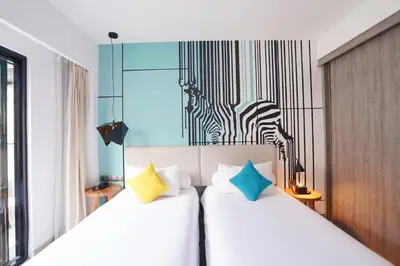a bedroom with two beds and a zebra picture on the wall at Kamaniiya Petitenget Seminyak in Seminyak